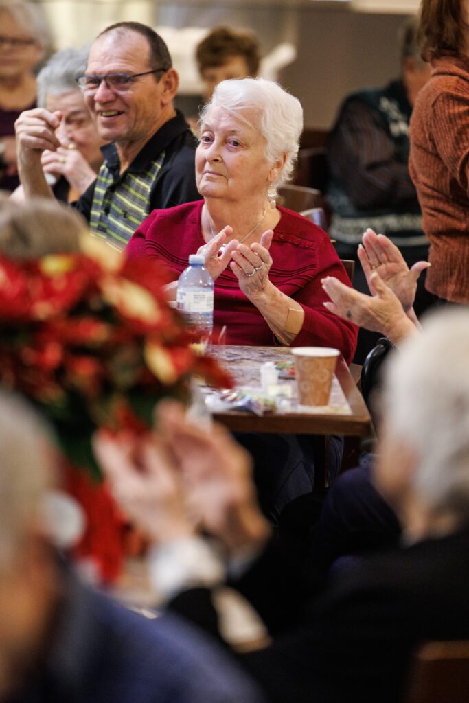 des ainés applaudissent pendant la prestation de Denis Miron